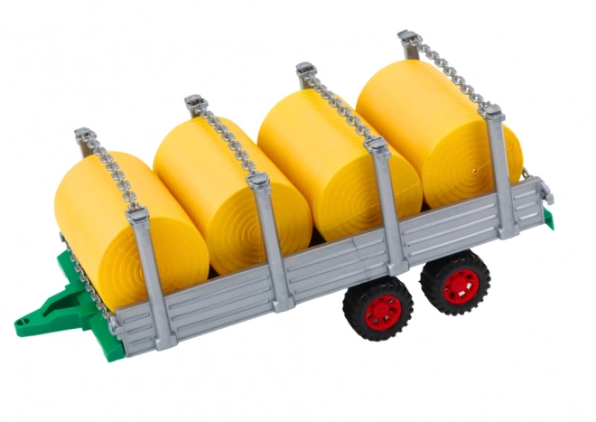 Velký traktor s přívěsem a balíky sena
